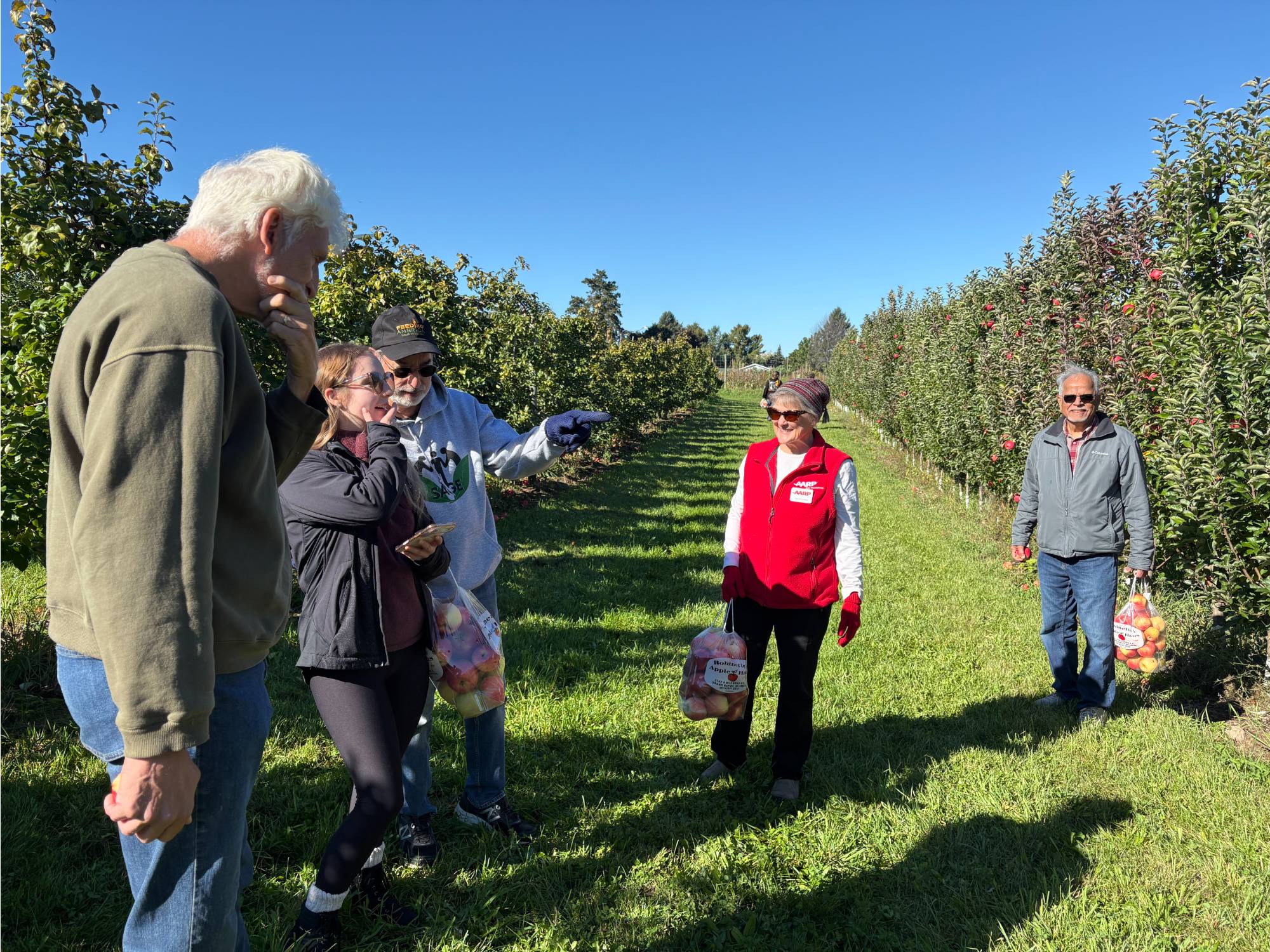 SAGE and Grand Connection members talking amidst picking apples